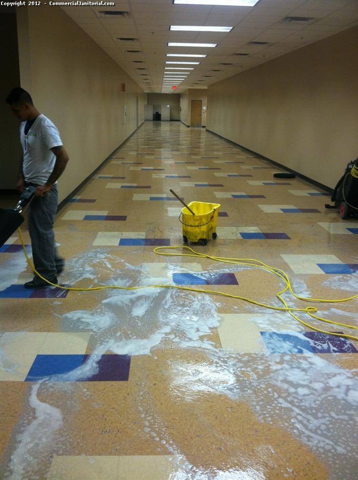 You see a long empty hallway with a shiny floor. We see Vinyl Composition Tile (VCT) that needs to be cleaned in a specific manner. Call Commercial Janitorial to discuss the way in which our team can clean your floors.