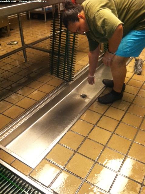 Cleaning out the stainless steel drains in the dish pit area
