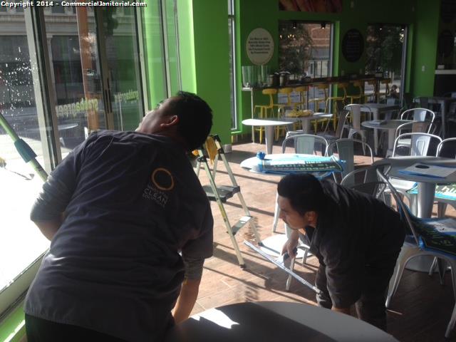 cleaners began cleaning windows from top to bottom , the crew member is assuring that no marks have been left by the squeegee cleaners seem to be doing a very good job windows are looking marvelous meeting clients expectations 